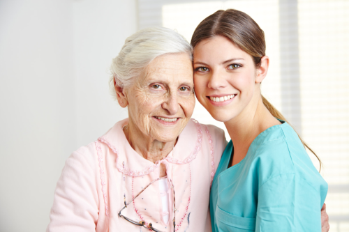 elderly woman with her caregiver smiling